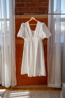 White midi dress with puff sleeves and fringe hem