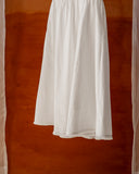 White midi dress with puff sleeves and fringe hem